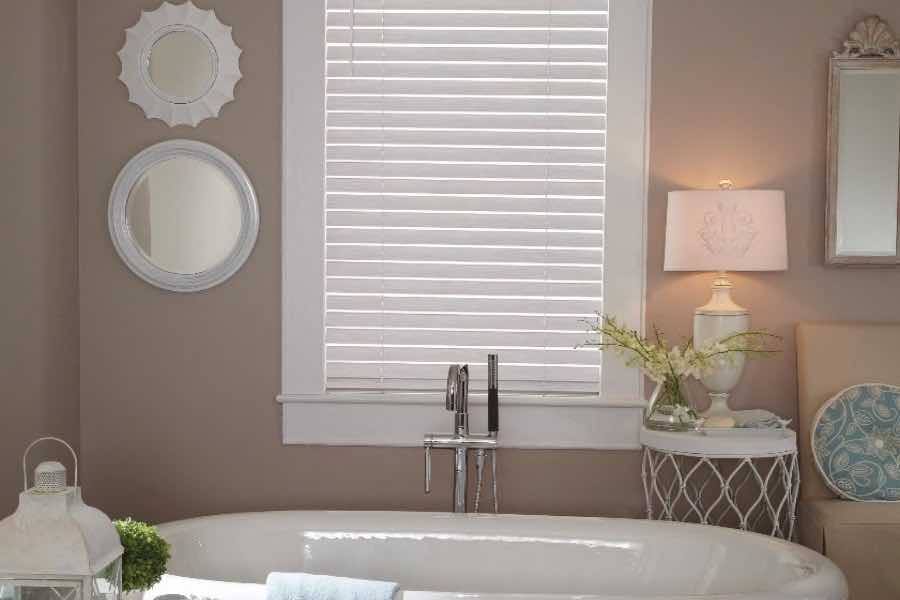 White faux wood blinds on a bathroom window